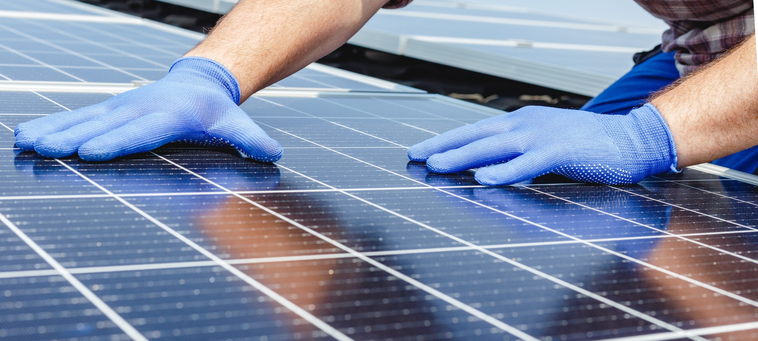 Gros plan sur les mains d'un installateur de panneaux solaires