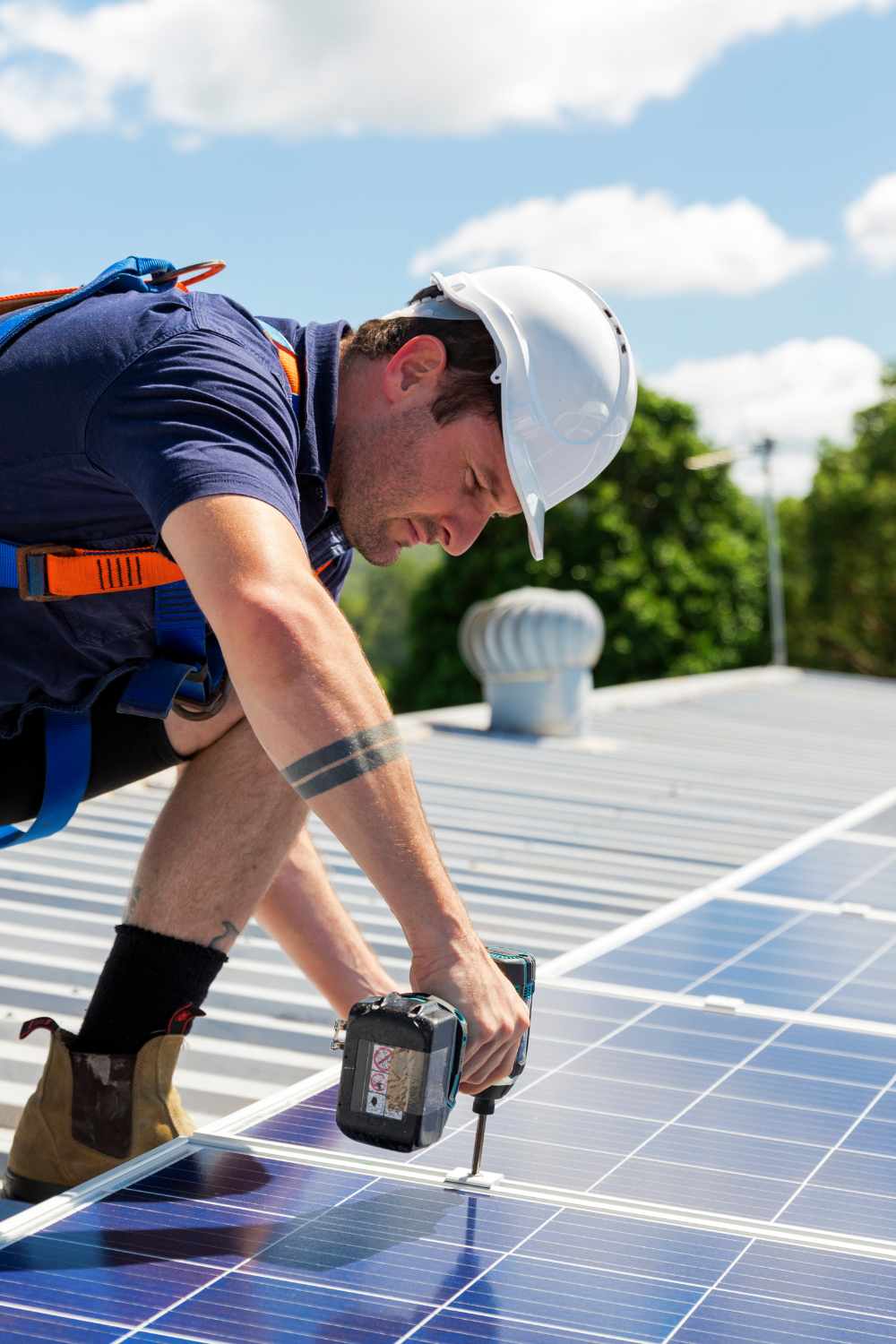 technicien solaire installateur de panneaux solaires entrain de fixer un panneaux